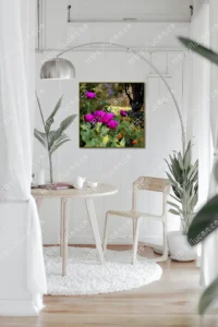 Tableau de grandes fleurs magenta ou violettes en gros plan dans un jardin, avec un cadre doré. Accroché dans une pièce lumineuse et minimaliste avec un tapis blanc et des plantes vertes.